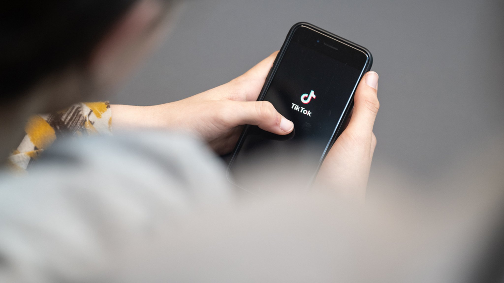 Jemand hält ein Smartphone in der Hand, auf dessen Display das TikTok-Logo zu sehen ist. | Bild: dpa-Bildfunk/Hannes P Albert Jemand hält ein Smartphone in der Hand, auf dessen Display das TikTok-Logo zu sehen ist.