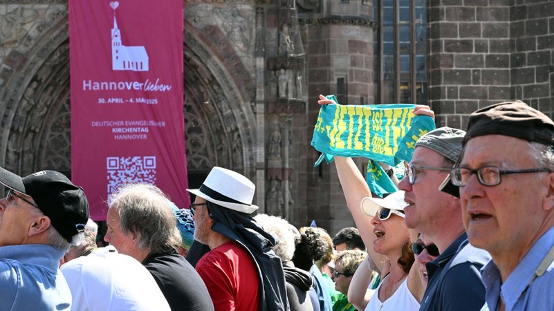 Eine Frau hält einen Schal des Kirchentags mit "Jetzt ist die Zeit" beim Abschlussgottesdienst des 38. Deutschen Evangelischen Kirchentags.