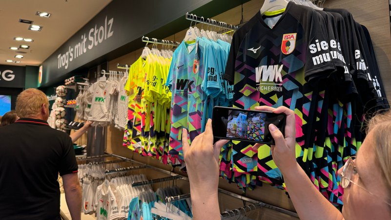 Im neuen Pop-up-Store in der Augsburger City-Galerie hängen sie schon: die neuen Heimtrikots des FC Augsburg für die kommende Saison.