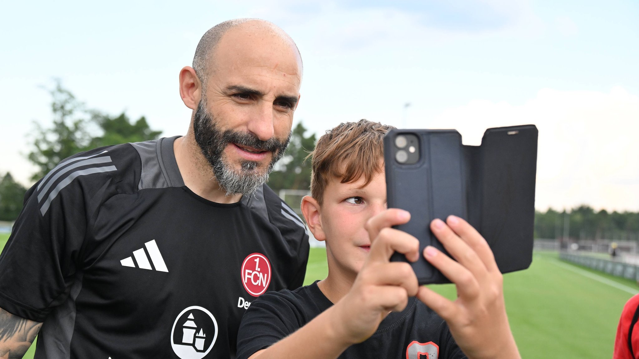 Javier Pinola, neuer Co-Trainer beim 1. FC Nürnberg, mit Fan beim Selfie