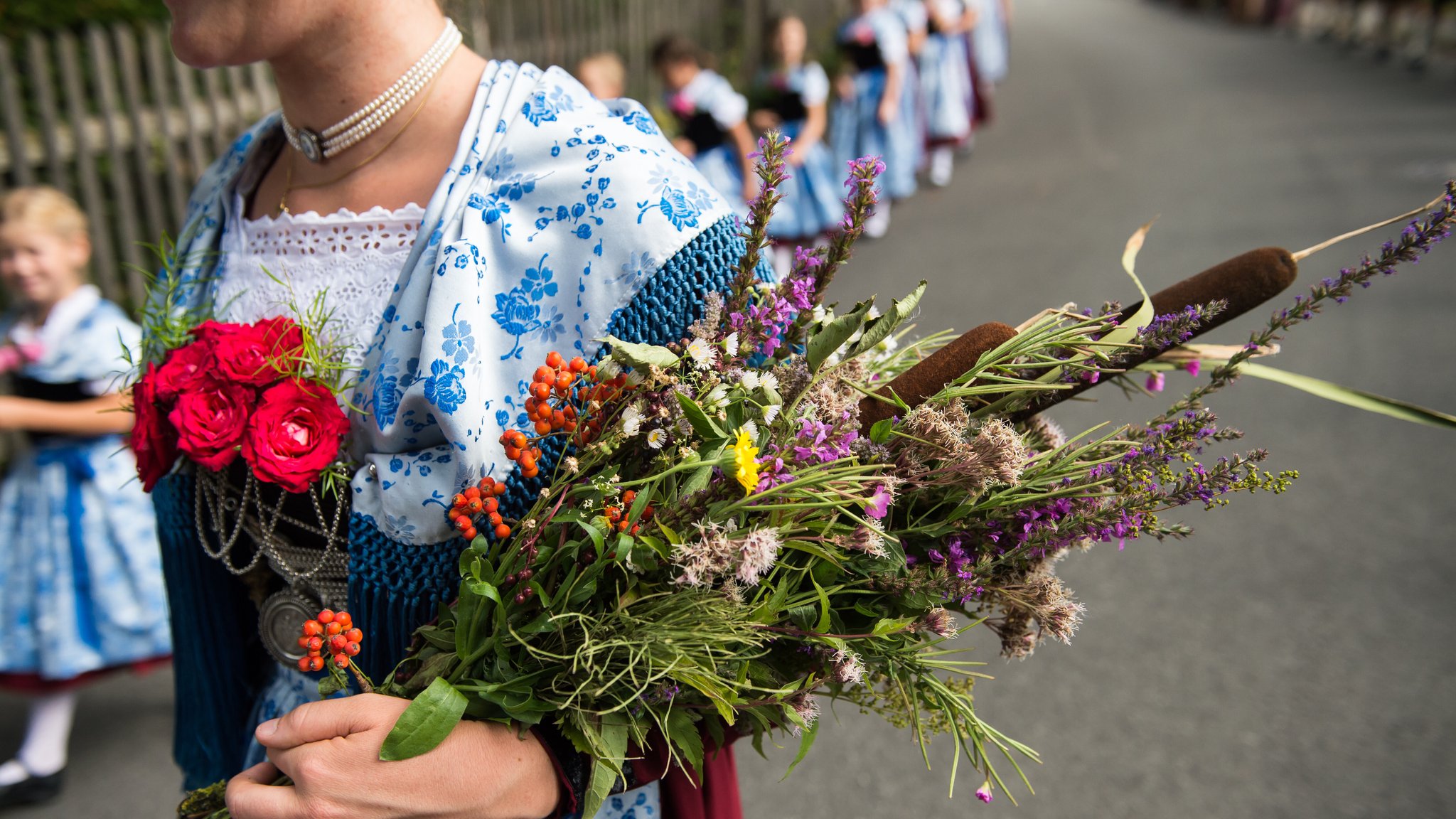 Archivbild: Mädchen in Tracht tragen an Mariä Himmelfahrt in Kochel am See beim Kirchenzug ihre Kräuterbuschen in die Kirche.