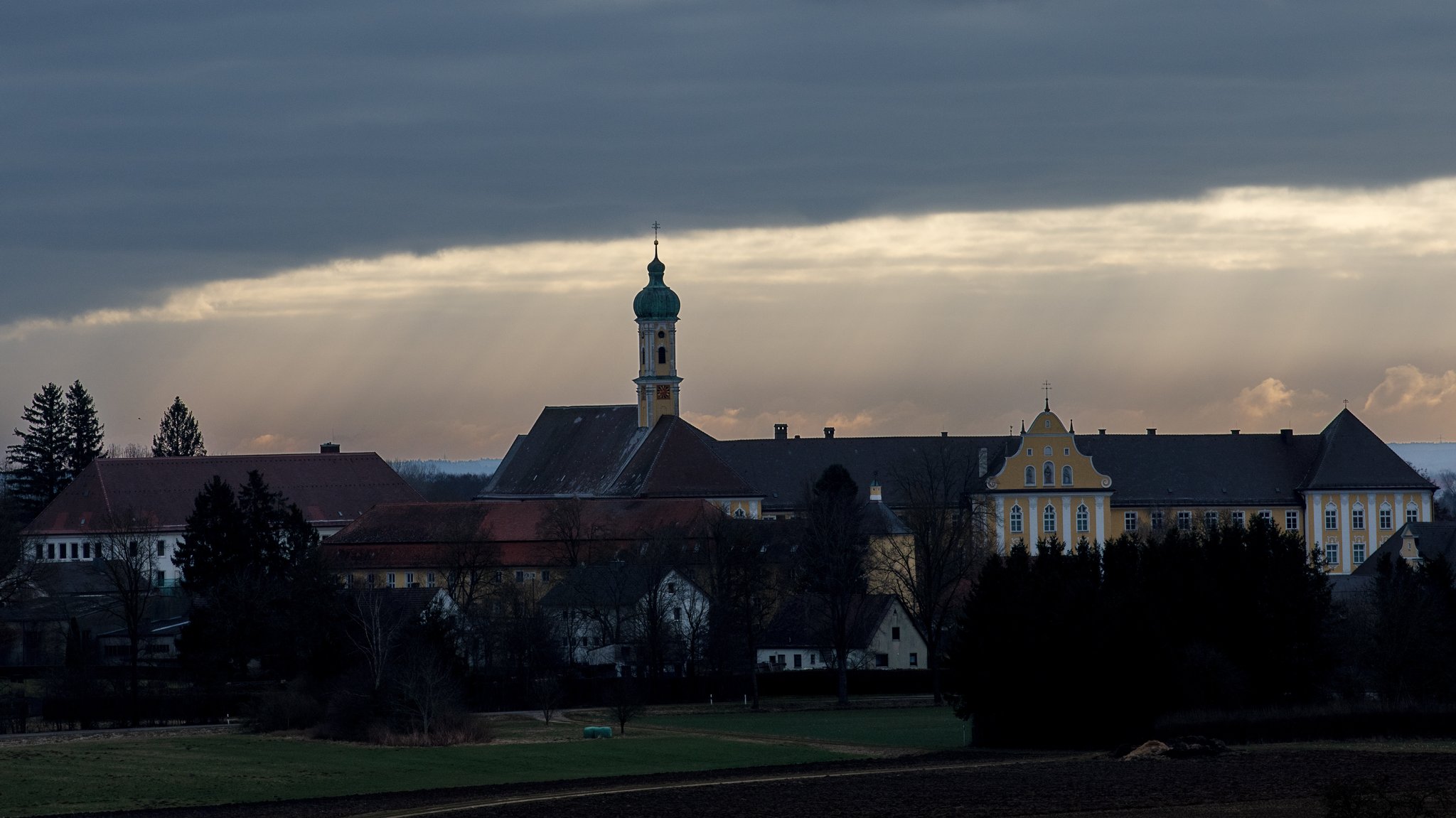 ARCHIV (26.02.2022): Der bedekte Himmel reisst hinter dem Kloster Maria Medingen auf. Das Wetter ist unbeständig, soll aber in den nächsten Tagen sonniger werden.