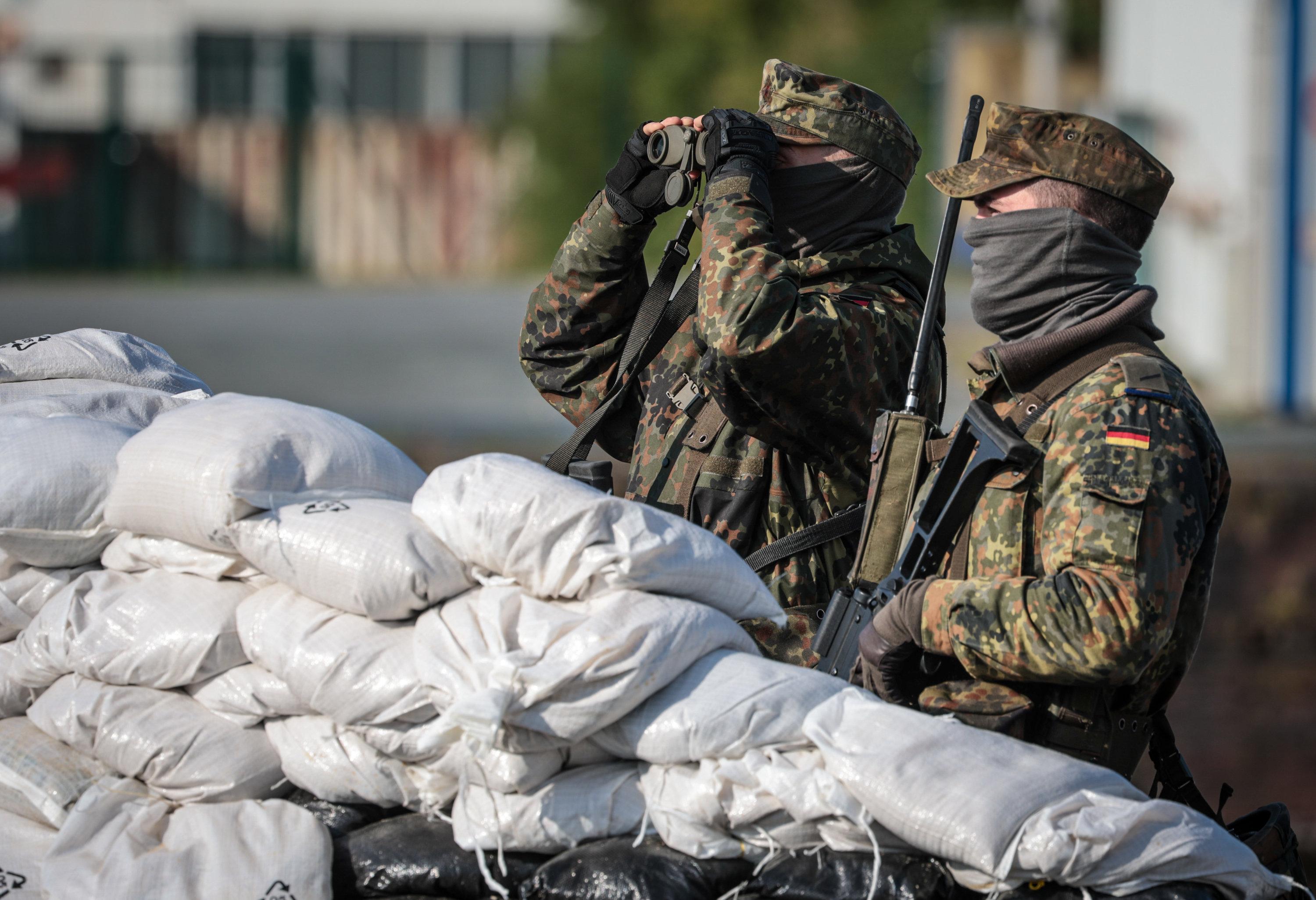 Zwei Soldaten stehen hinter einem Sandsackwall während der Bundeswehr-Übung "Fishtown Guard 2024" in Bremerhaven (Archivbild)