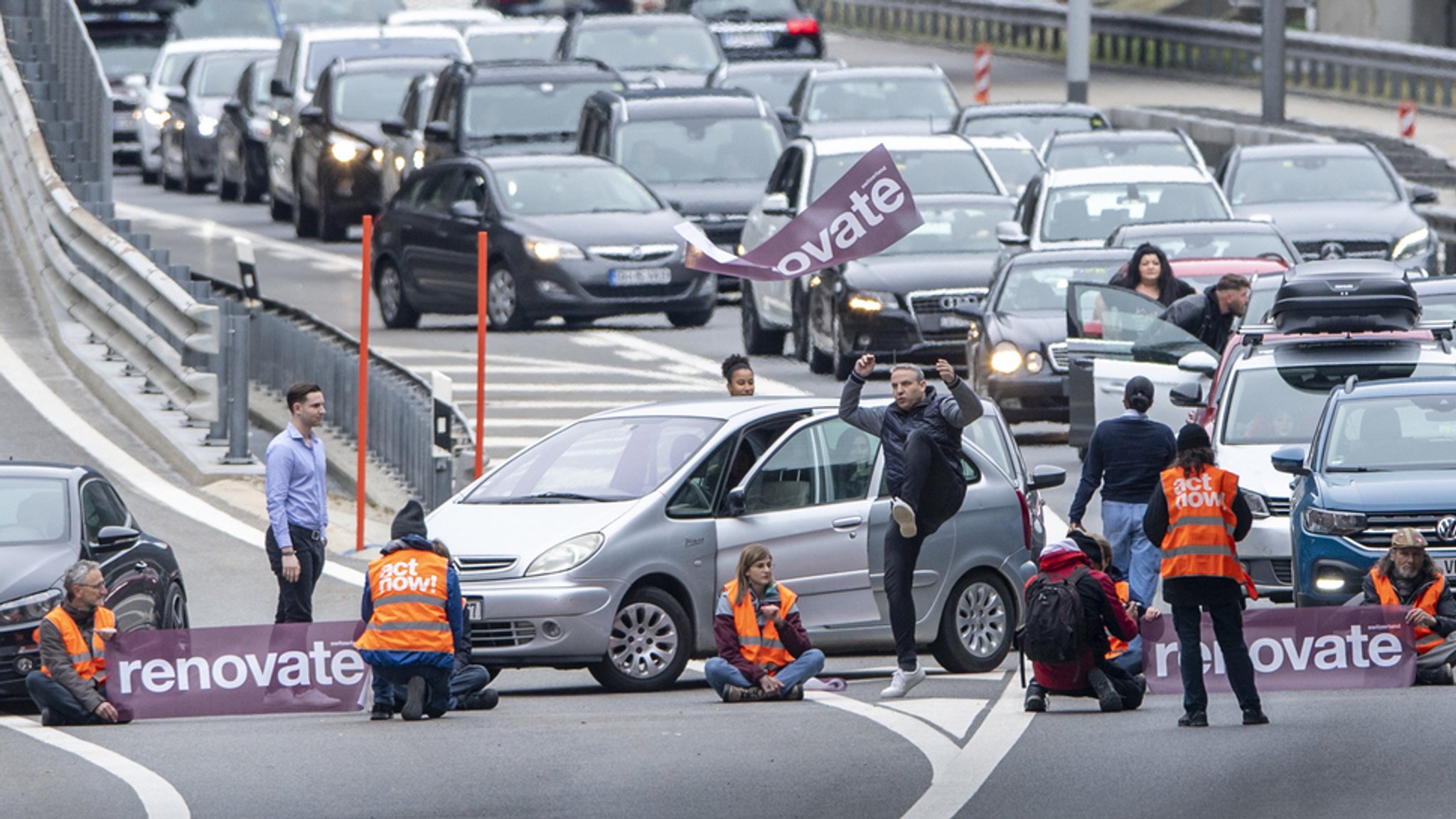 Klimaaktivisten von "Renovate Switzerland" kleben auf der Fahrbahn vor dem Nordportal des Gotthard-Straßentunnels.