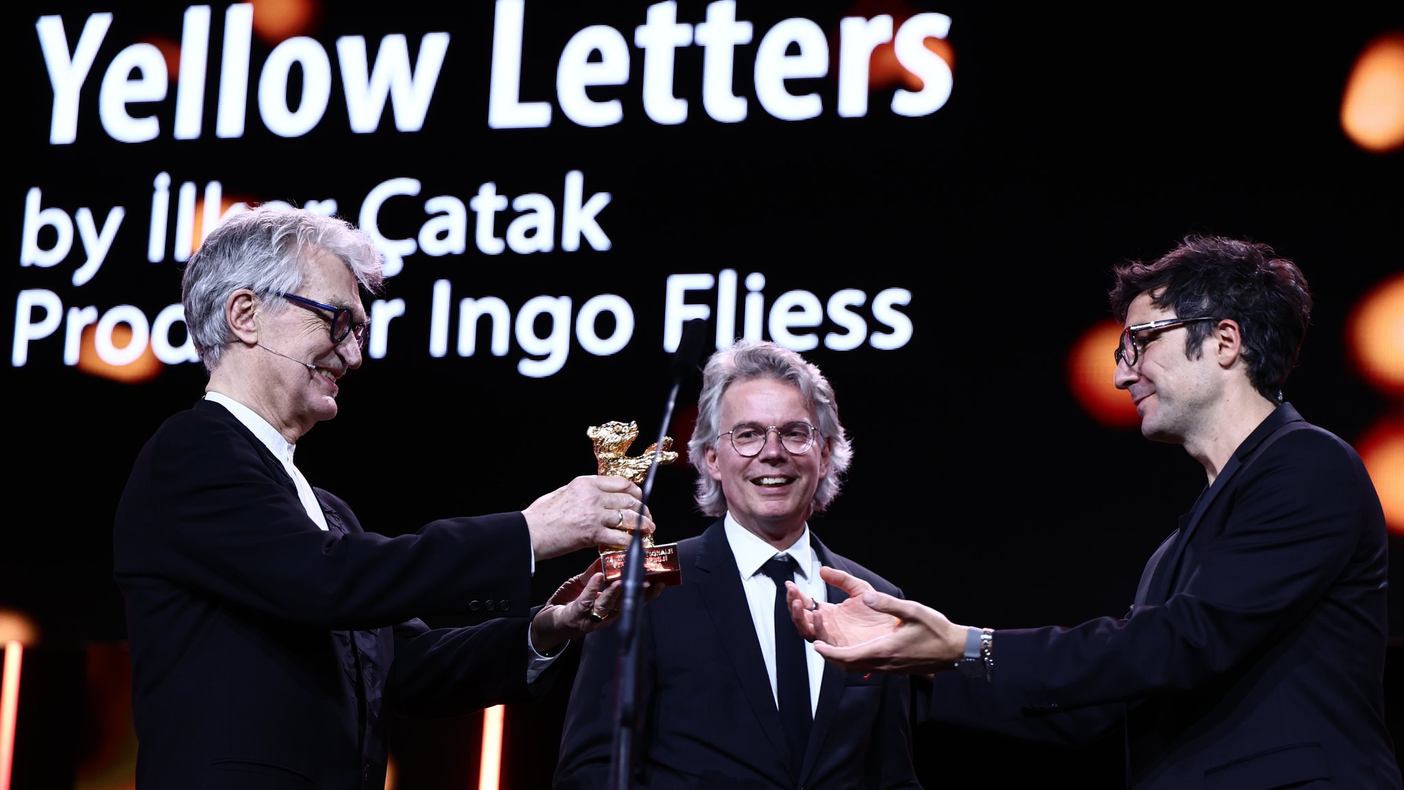 Wim Wenders, Jury-Präsident der 76. Berlinale, überreicht Regisseur Ilker Çatak den Goldenen Bären für das Drama "Gelbe Briefe" | Bild: picture alliance/dpa | Christoph Soeder Wim Wenders, Jury-Präsident der 76. Berlinale, überreicht Regisseur Ilker Çatak den Goldenen Bären für das Drama "Gelbe Briefe"