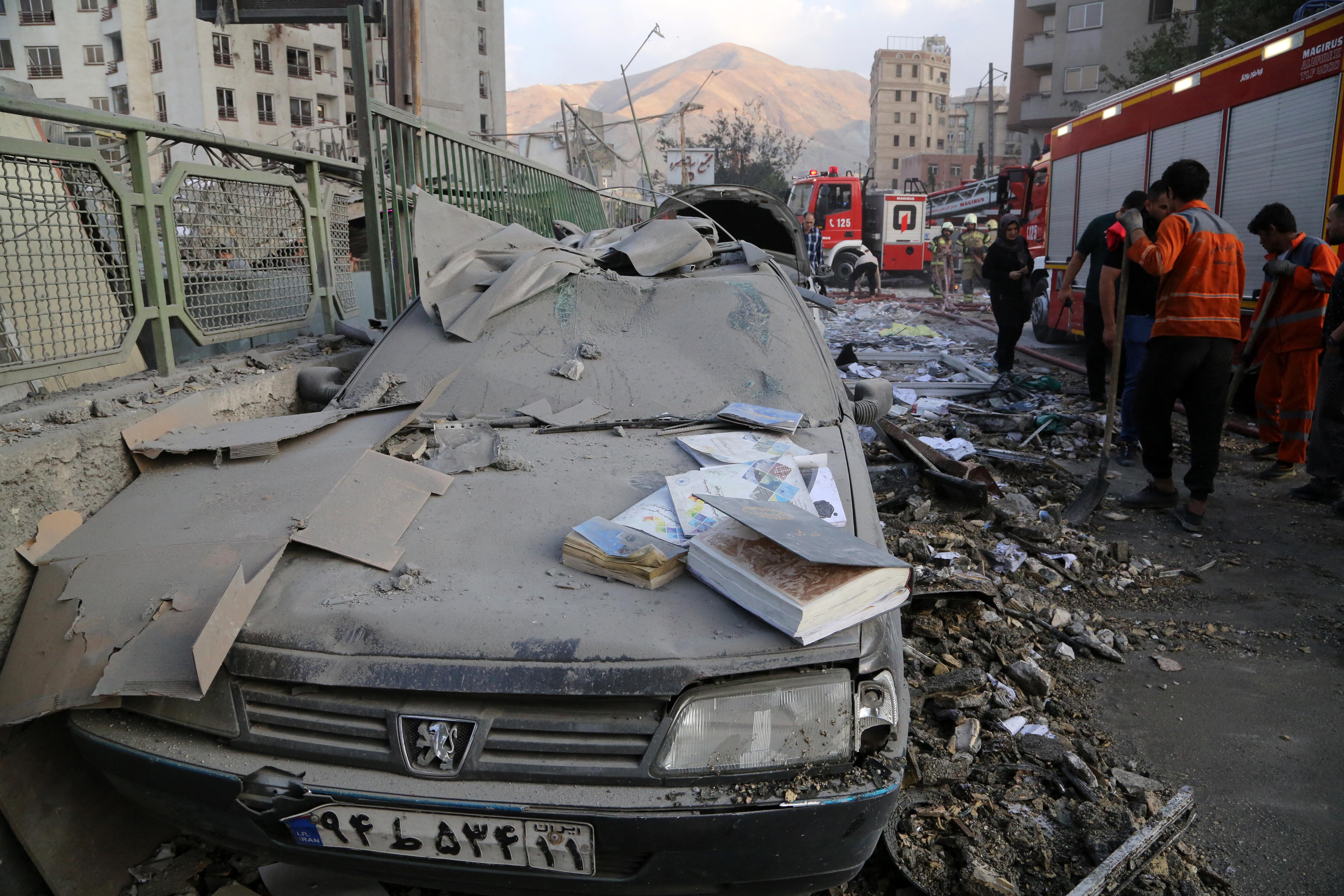 Hilfskräfte beseitigen nach dem israelischen Angriff Trümmer in Teheran.