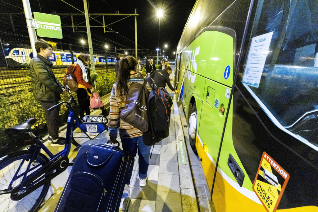 Reisende versammeln sich am Einstiegspunkt am Bahnhof Maastricht zur Abfahrt des Flixbus nach Kiew. 