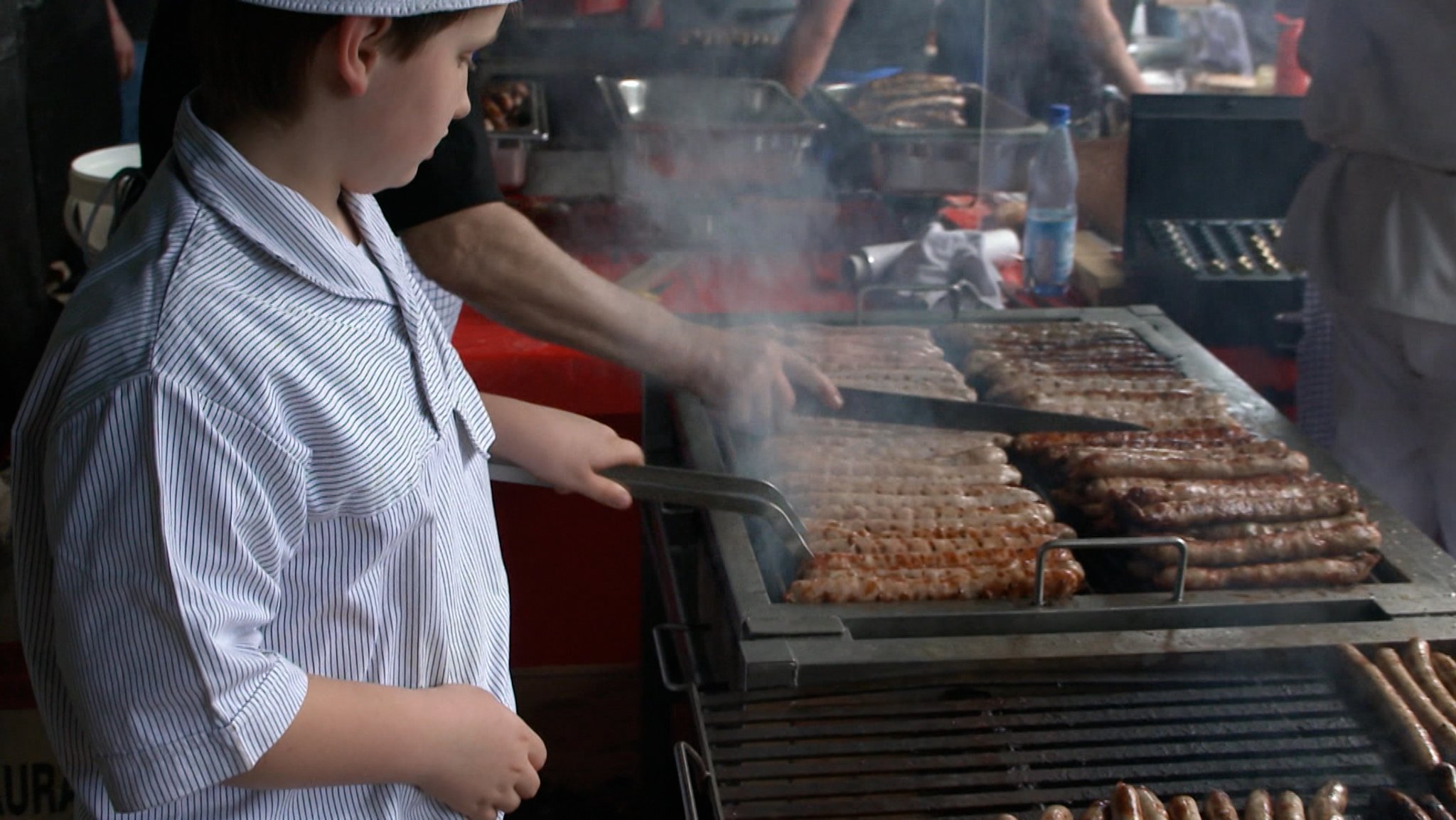 Bratwürste werden auf einem Grill gebraten. 