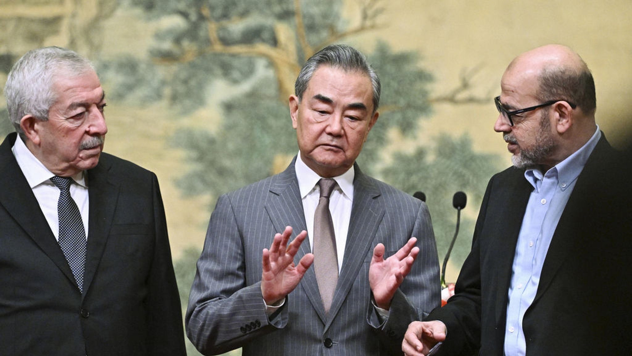 23.07.2024, China, Peking: Chinas Außenminister Wang Yi (M) ist Gastgeber eines Treffens zwischen Mahmoud al-Aloul (l), dem stellvertretenden Vorsitzenden der Fatah, und Mussa Abu Marzuk, einem hochrangigen Mitglied der Hamas, im Diaoyutai State Guesthouse.  Die rivalisierenden Palästinenserorganisationen Hamas und Fatah haben nach Angaben chinesischer Staatsmedien eine Beendigung ihres langjährigen Konflikts vereinbart. Foto: Pedro Pardo/Pool AFP via AP/dpa +++ dpa-Bildfunk +++