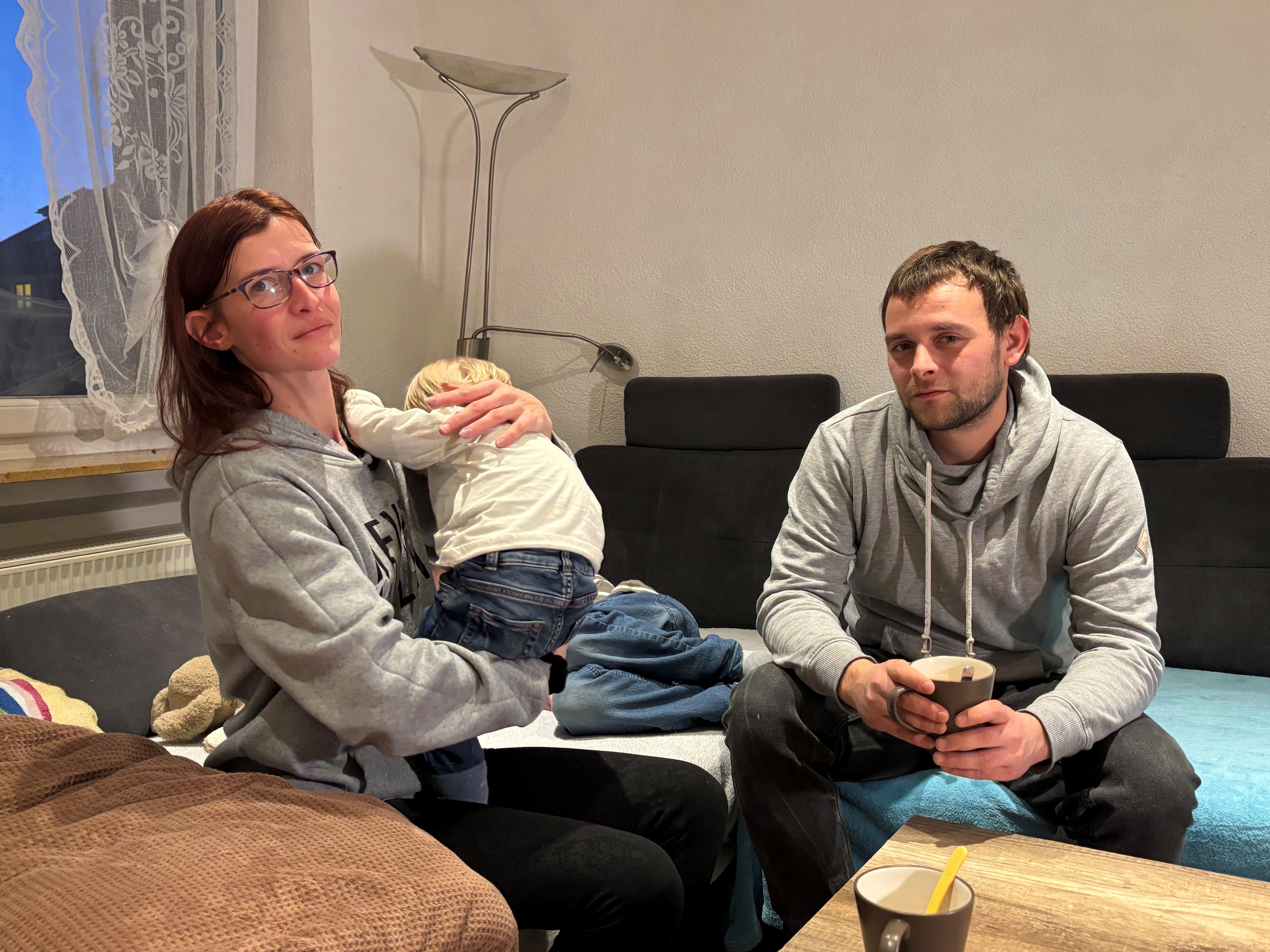 Eltern mit Kind auf dem Sofa. Sie suchen eine neue Wohnung.