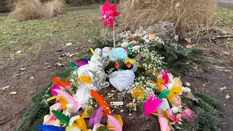 "Wir vermissen dich" steht auf einem Herz, das auf einem geschmückten Grab liegt. | Bild: BR/Sophia Ruhstorfer "Wir vermissen dich" steht auf einem Herz, das auf einem geschmückten Grab liegt.