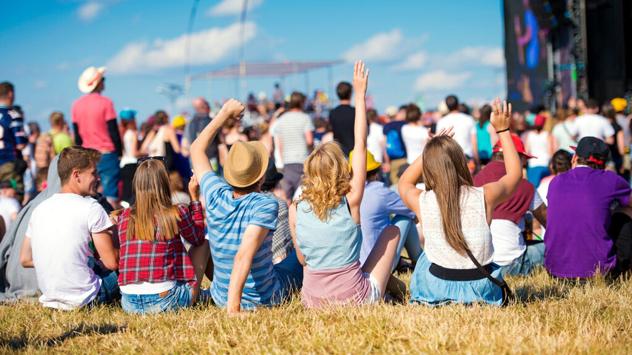 Menschen genießen ein Sommerfestival unter freiem Himmel. | Bild: stock.adobe.com/Halfpoint Menschen genießen ein Sommerfestival unter freiem Himmel.
