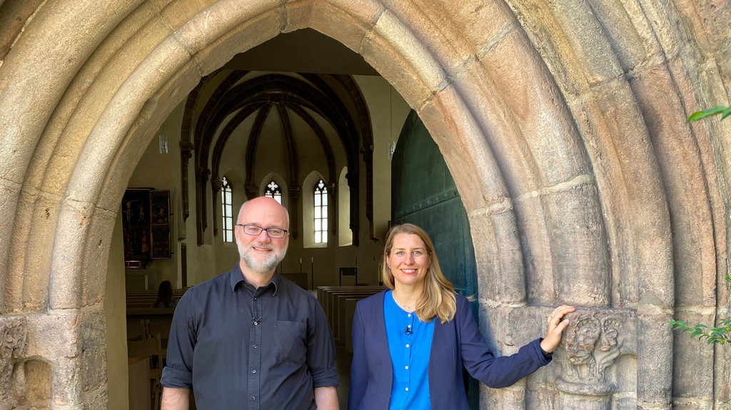 Jesuitenpater Ansgar Wiedenhaus und Moderatorin Anna Kemmer vor der Pforte der Offenen Kirche St. Klara in Nürnberg