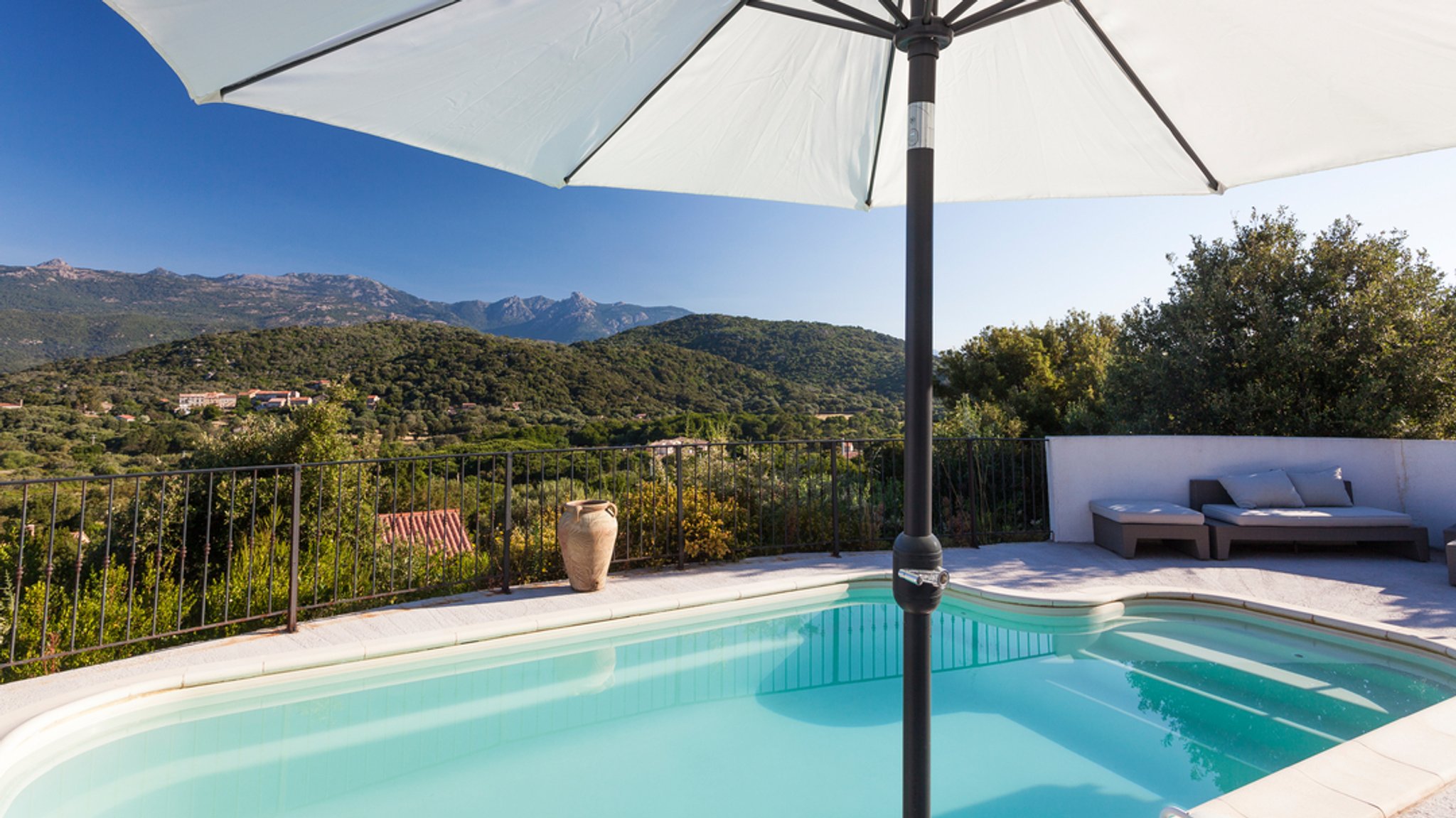 Mittelmeerlandschaft mit Pool und Sonnenschirm