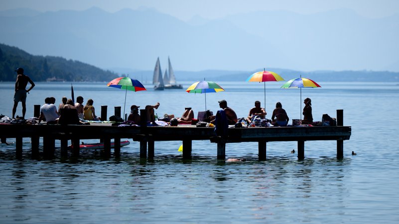 Menschen genießen das Wetter und den Sonnenschein auf einem Steg am Starnberger See. (Archivbild) | Bild: picture alliance/dpa | Sven Hoppe Menschen genießen das Wetter und den Sonnenschein auf einem Steg am Starnberger See. (Archivbild)