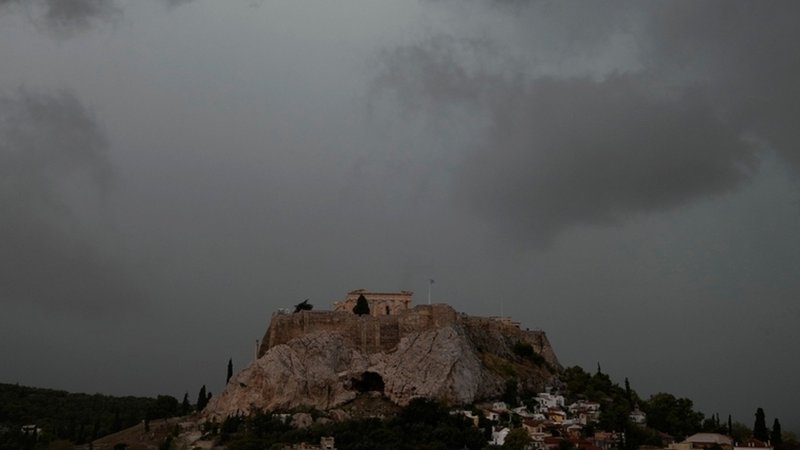Archivbild: Graue Wolken bedecken den Himmel über dem Akropolis-Hügel während eines Regenschauers. | Bild: dpa-Bildfunk/Thanassis Stavrakis Archivbild: Graue Wolken bedecken den Himmel über dem Akropolis-Hügel während eines Regenschauers.