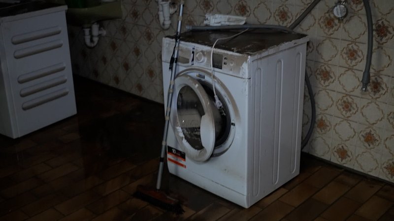 Vom Hochwasser zerstörte Waschmaschine steht in einem Keller
