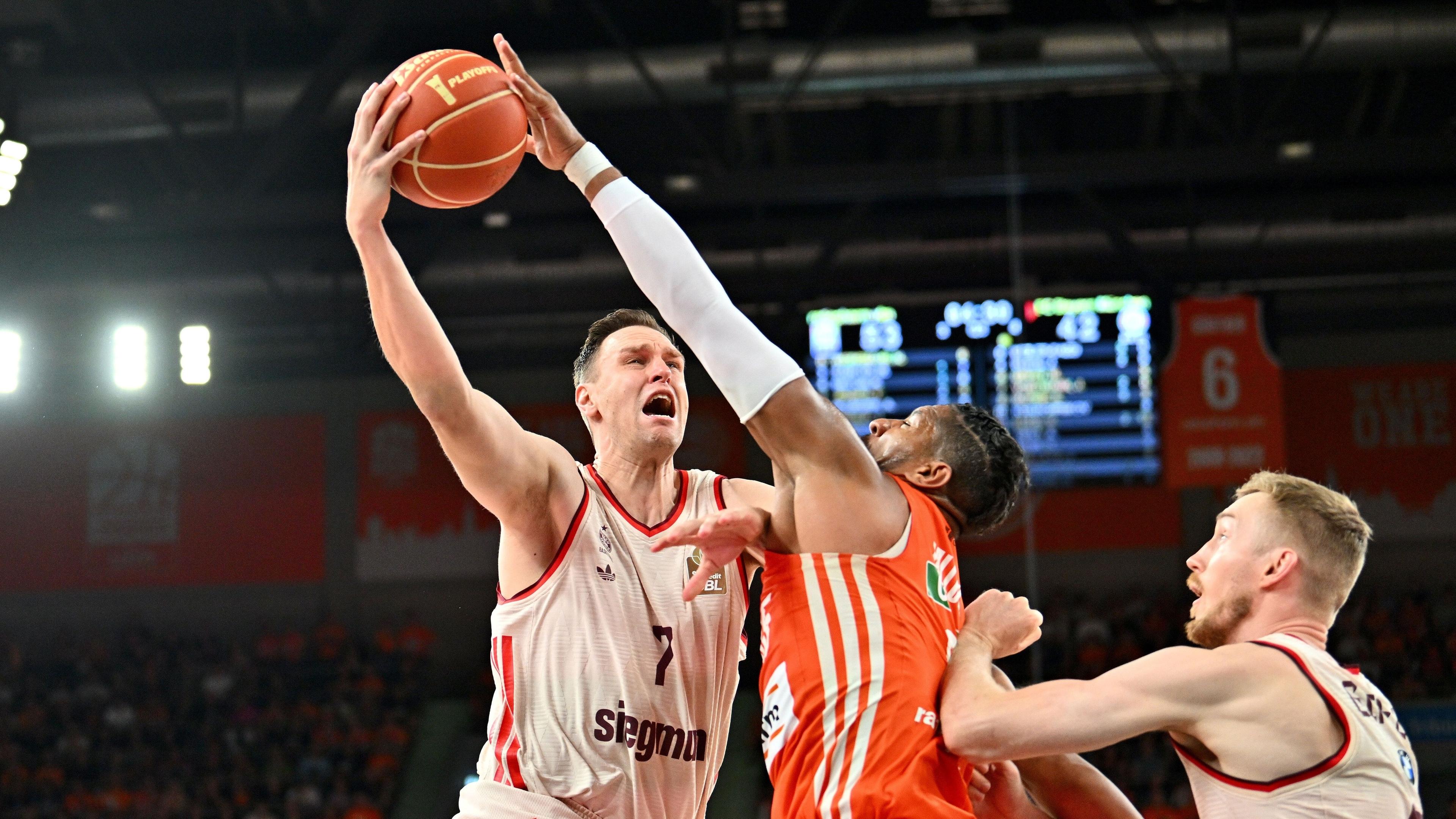 Münchens Johannes Voigtmann (l) im Duell mit Ulms Karim Jallow (M)