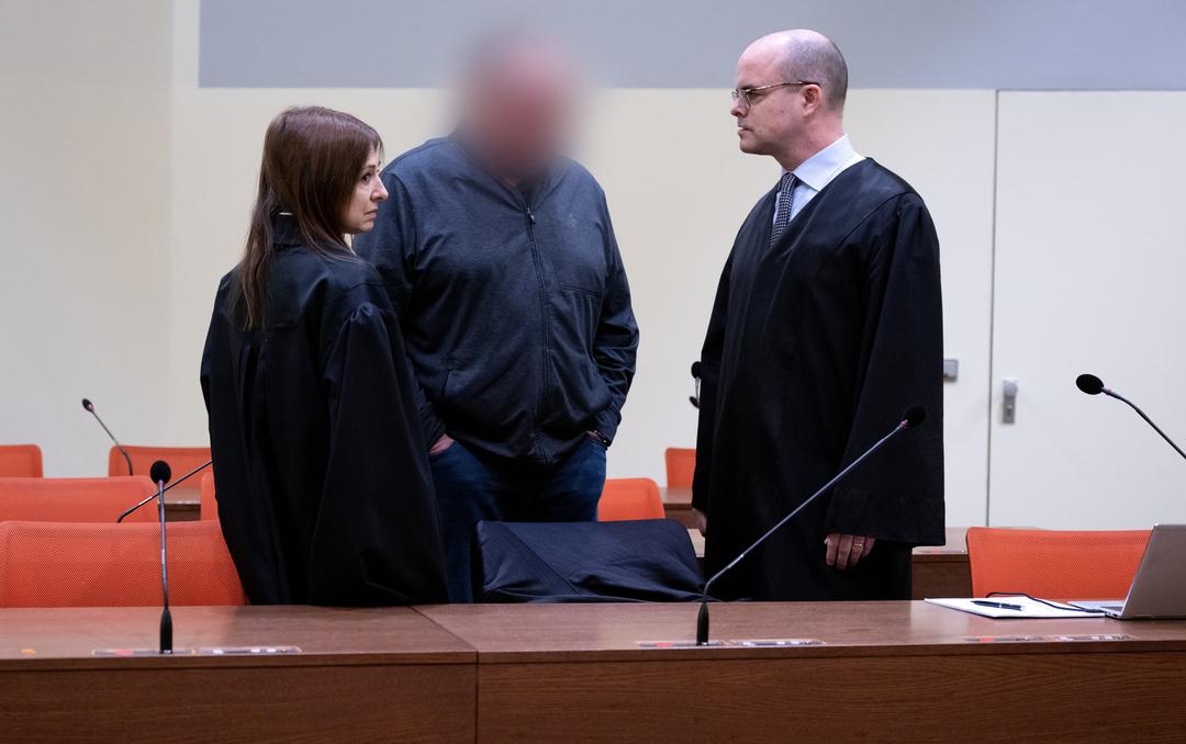 Der wegen fahrlässiger Tötung und fahrlässiger Körperverletzung angeklagte Mann (Mitte, Gesicht verpixelt) steht vor Prozessbeginn mit seinen Anwälten Stephan Beukelmann (r) und Mariana Sacher im Gerichtssaal.