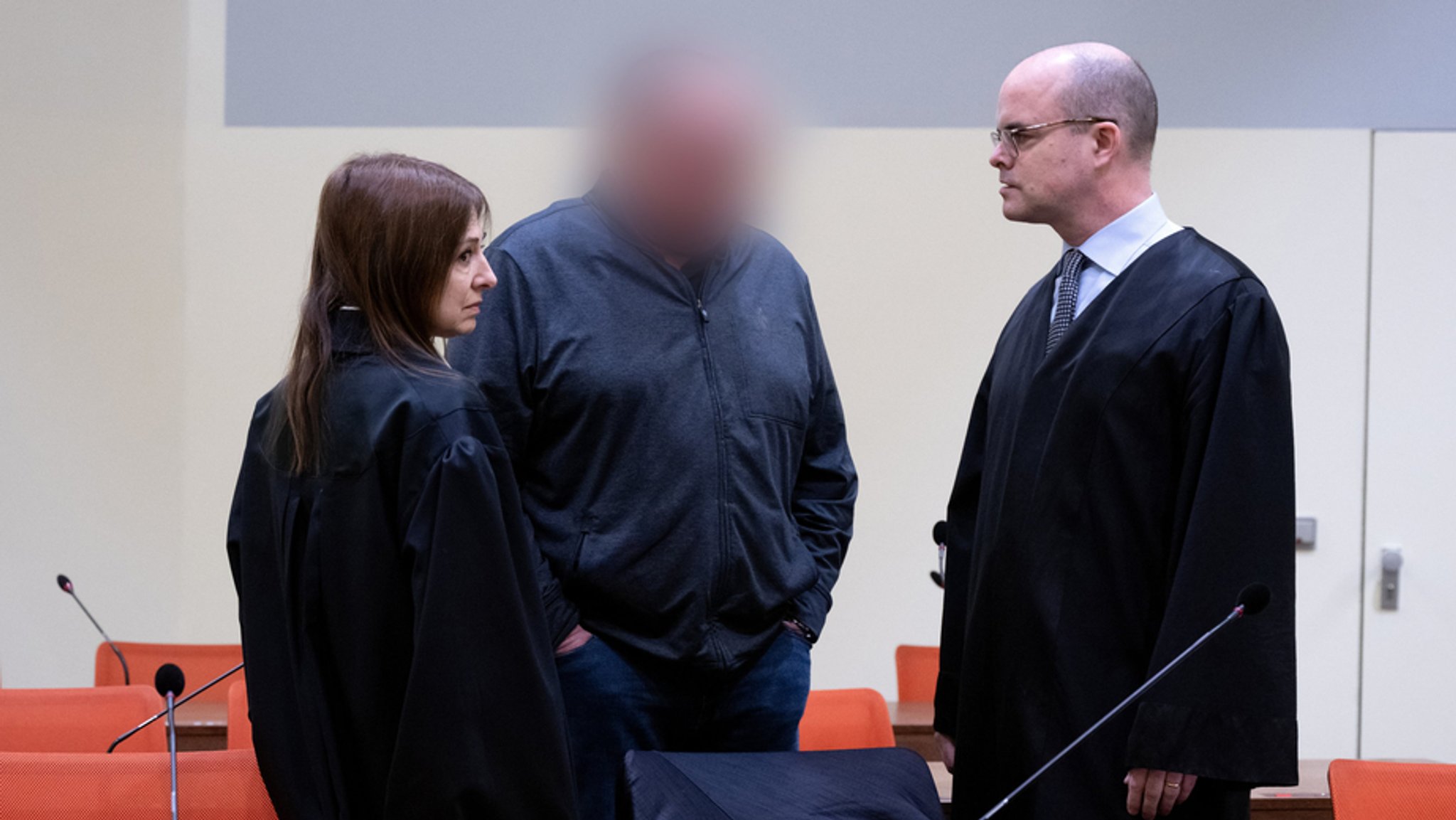 Der wegen fahrlässiger Tötung und fahrlässiger Körperverletzung angeklagte Mann (Mitte, Gesicht verpixelt) steht vor Prozessbeginn mit seinen Anwälten Stephan Beukelmann (r) und Mariana Sacher im Gerichtssaal.