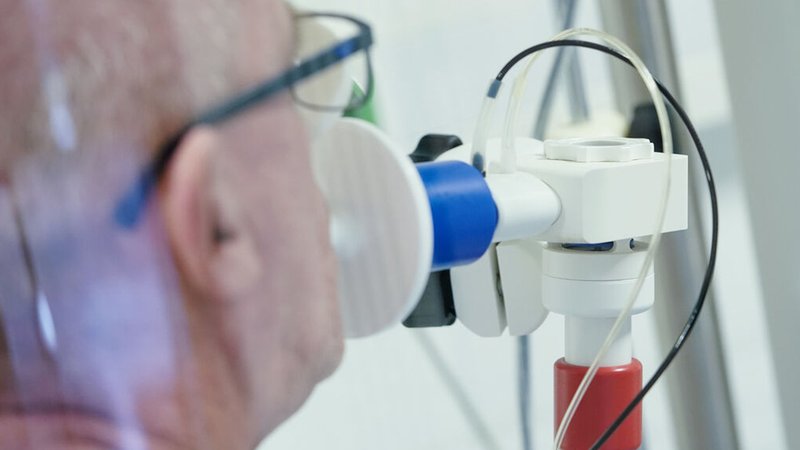 Ein von einer Corona-Erkrankung genesener Patient bekommt in einer Lungentest-Kabine in einer Rehaklinik die Lungenfunktion gemessen