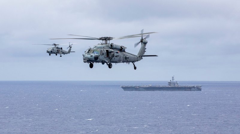 Hubschrauber vor dem Flugzeugträger USS Abraham Lincoln | Bild: Jerome D. Johnson//U.S. Navy/ZUMA Press Wire/dpa Hubschrauber vor dem Flugzeugträger USS Abraham Lincoln