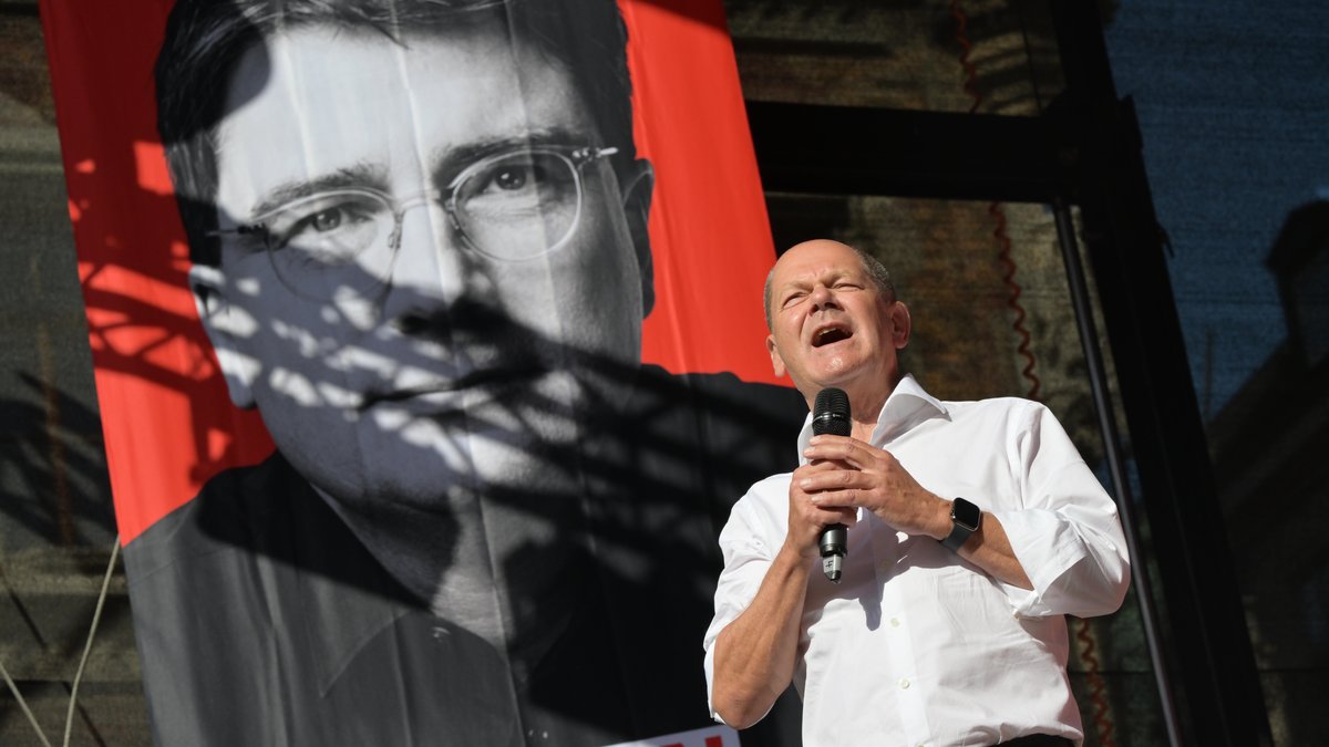 Bundeskanzler Olaf Scholz beim Wahlkampfauftakt der bayerischen SPD in München. Im Hintergrund ein Plakat von Spitzenkandidat Florian von Brunn.