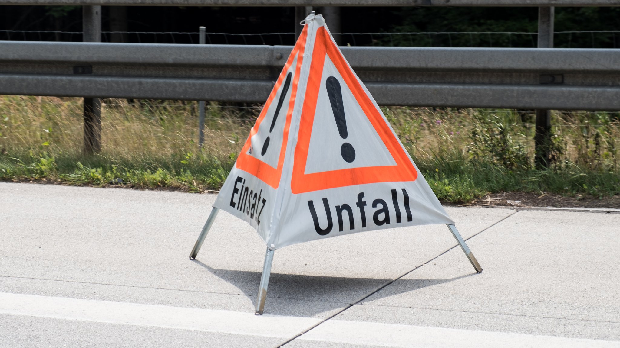 Eine Warnpyramide mit der Aufschrift "Unfall" steht auf dem Standstreifen einer Straße (Symbolbild)