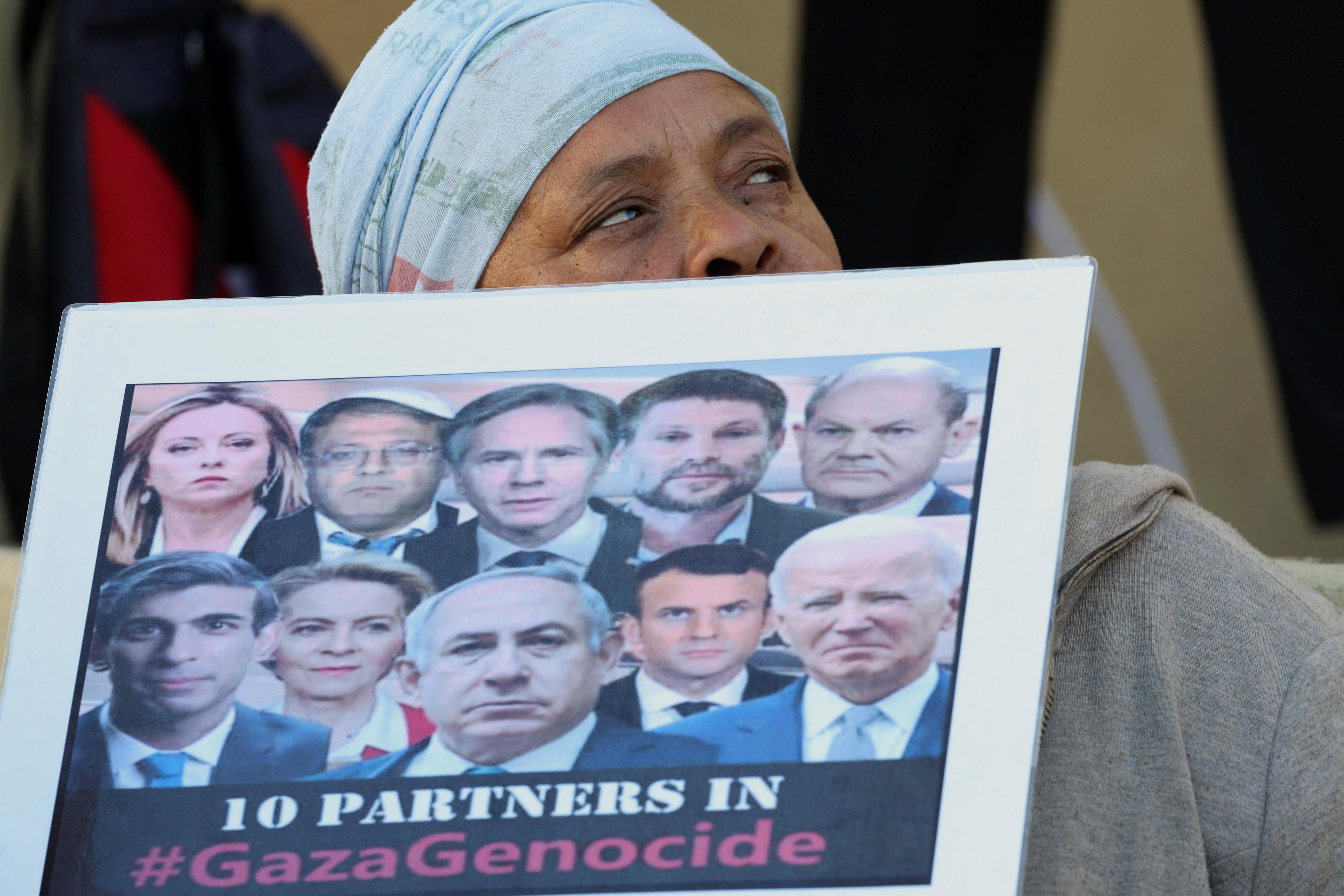 Frau hält Schild mit angeblichen "Völkermords-Unterstützern" aus der Politik