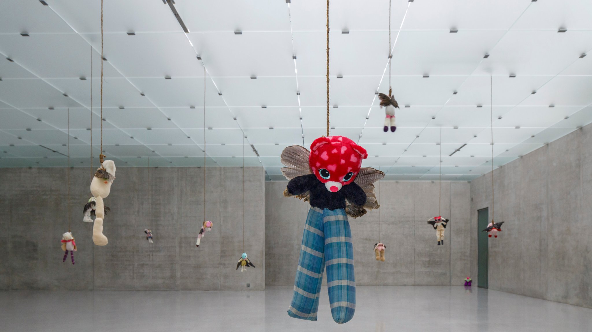 Von der Decke eines der Räume im Kunsthaus Bregenz hängen mehrere Kuscheltiere herab, angeleint an einen Strick.