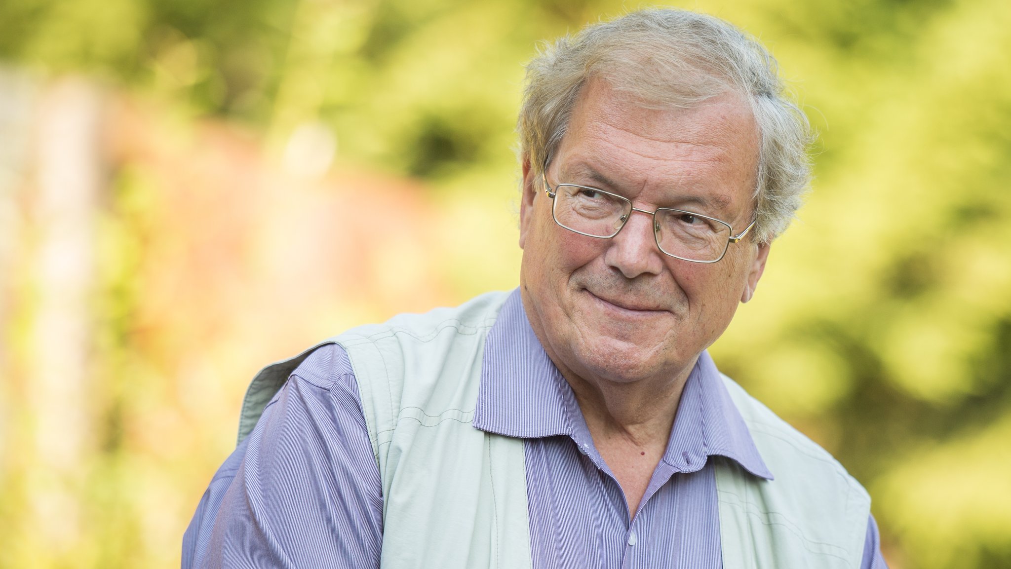 Porträtbild von Hubert Weiger vor verschwommenem Naturhintergrund