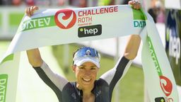Anne Haug hält das Zielbanner des Challenge Roth in die Höhe. | Bild:dpa-Bildfunk/Timm Schamberger