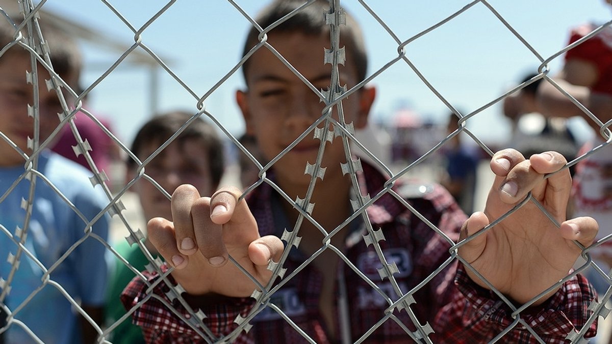 Hinterm Zaun: Flüchtlingskinder in einem im Flüchtlingslager im türkischen Kahramanmaras (Archivbild/Symbolbild)