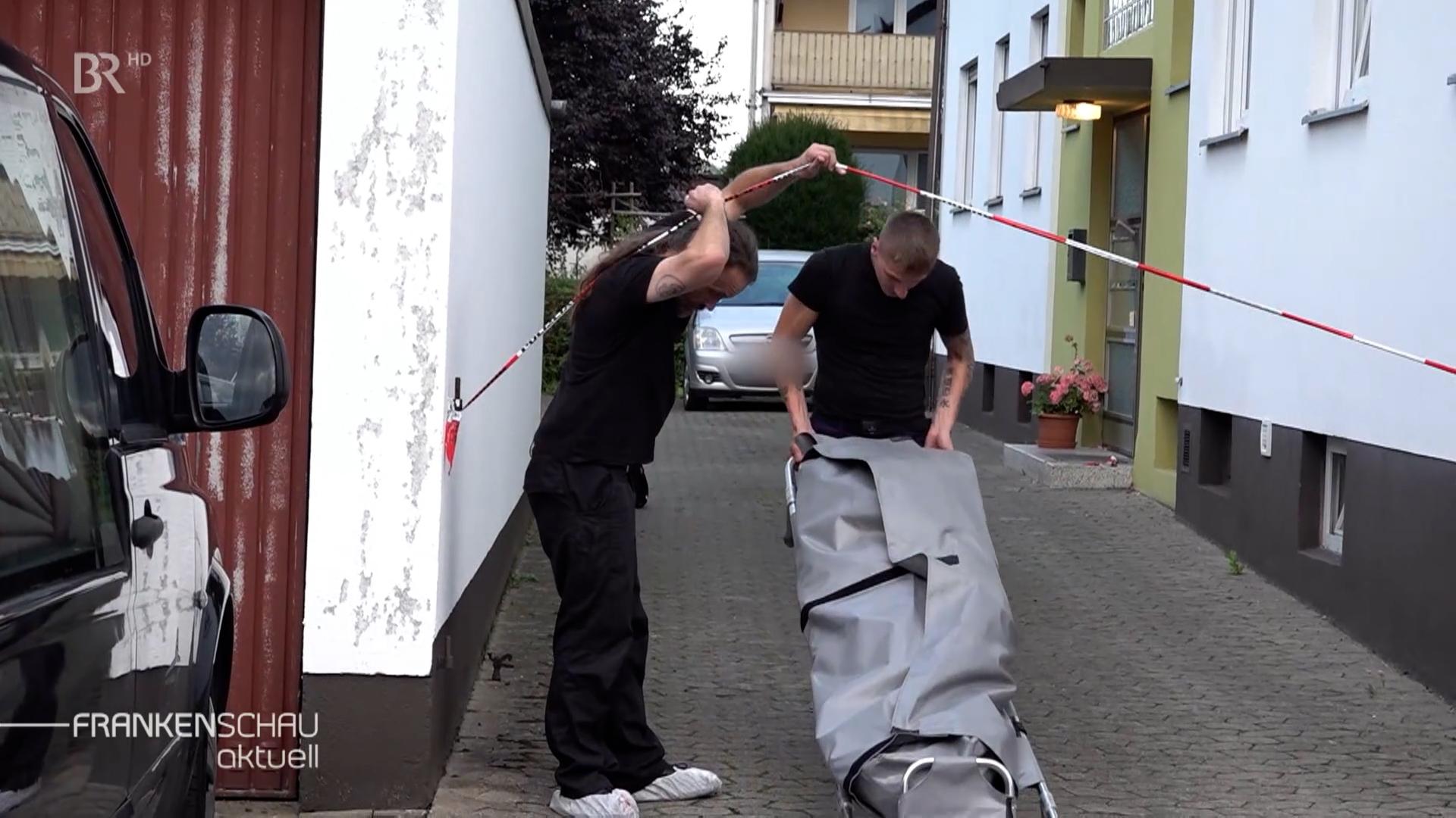 Mann mit Leichensack.