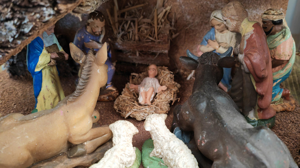 Krippe mit Figuren: Jesukind, Maria und Josef und die Heiligen Drei Könige. Dazu Esel, Ochse und Schafe