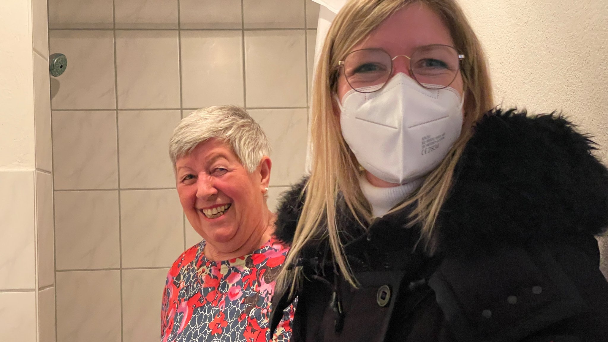 Hildegard Lustig und Daniela Schmidt (mit Maske) im Gästebad von Hildegard Lustig.