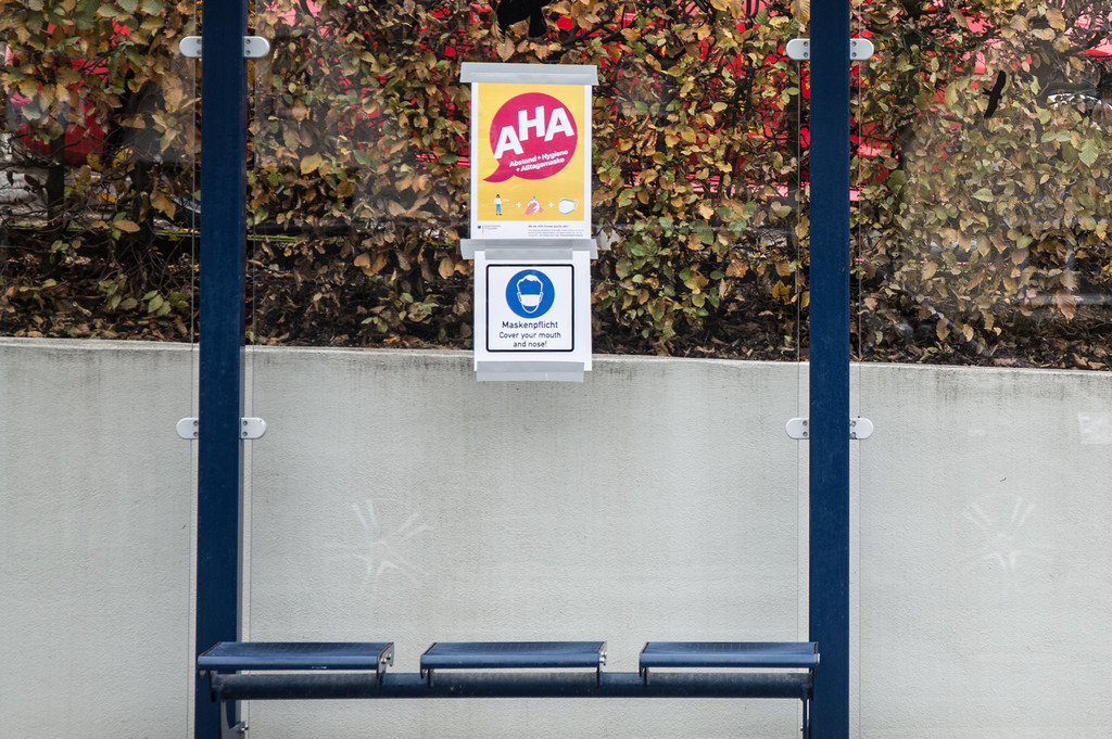 Aufruf zum Einhalten der AHA-Regeln an einer Bushaltestelle
