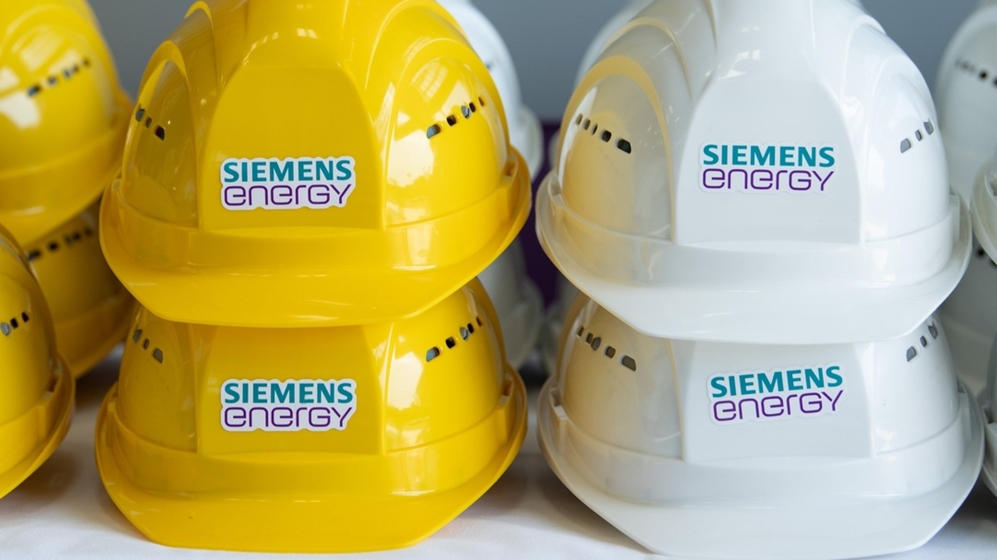 Schutzhelme mit der Aufschrift "Siemens Energy" liegen in einer Halle auf einem Tisch. | Bild: dpa-Bildfunk/Sebastian Kahnert Schutzhelme mit der Aufschrift "Siemens Energy" liegen in einer Halle auf einem Tisch.