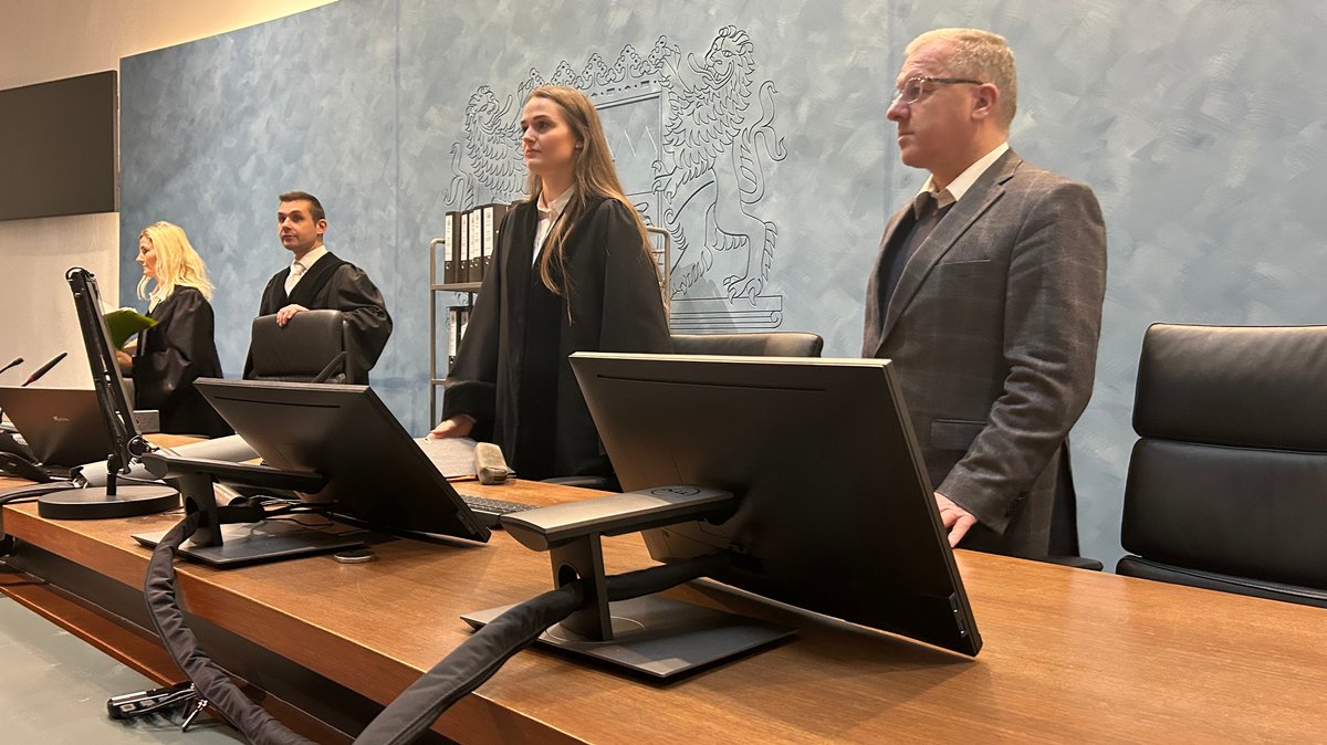 Der Gerichtssaal des Landgerichts Hof. Vorne am Richterpult stehen zwei Männer und eine Frau. 