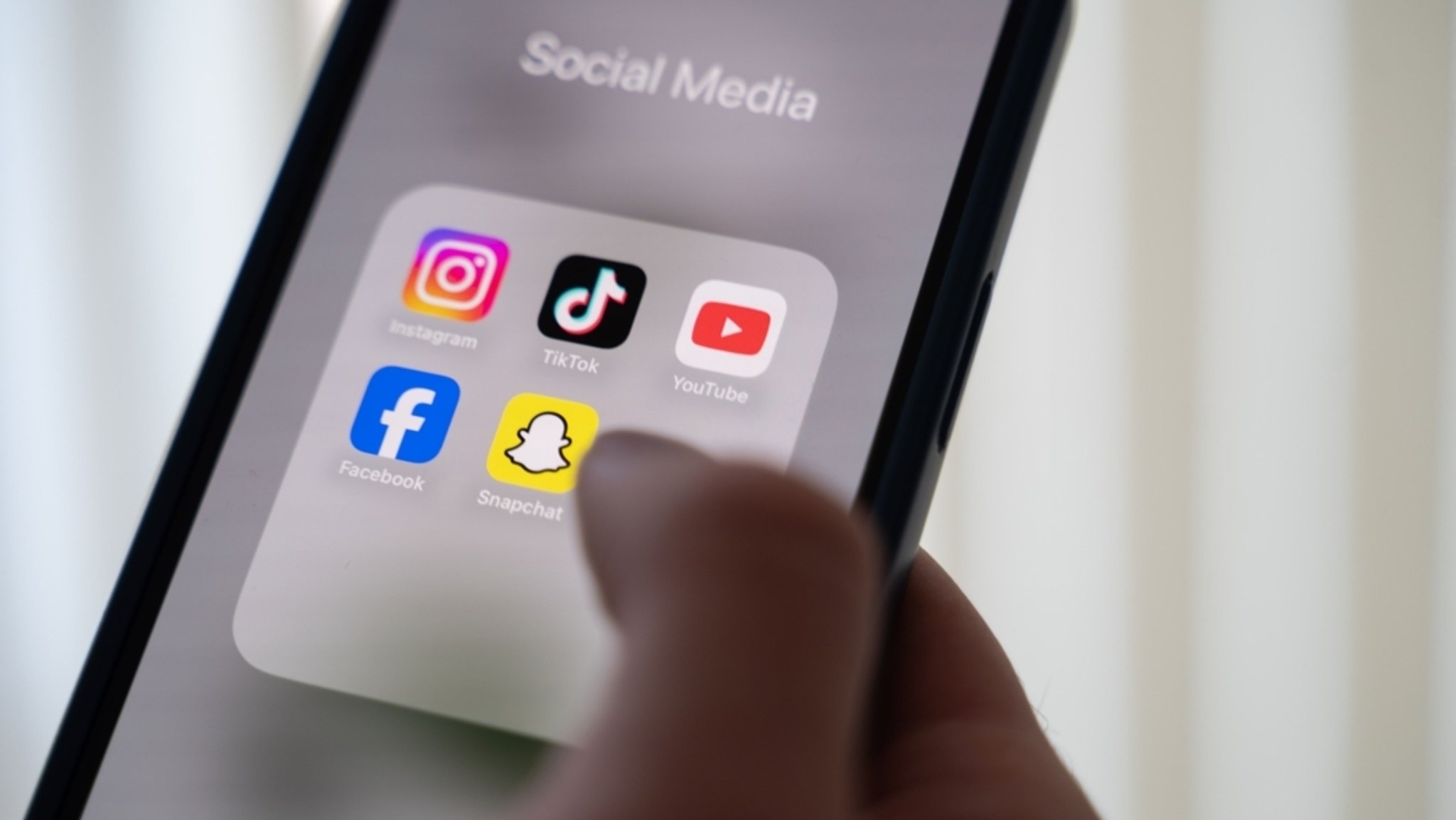 Eine Frau hält ein Smartphone, auf dessen Display verschiedene Social Media Apps angezeigt werden. | Bild: dpa-Bildfunk/Alicia Windzio Eine Frau hält ein Smartphone, auf dessen Display verschiedene Social Media Apps angezeigt werden.