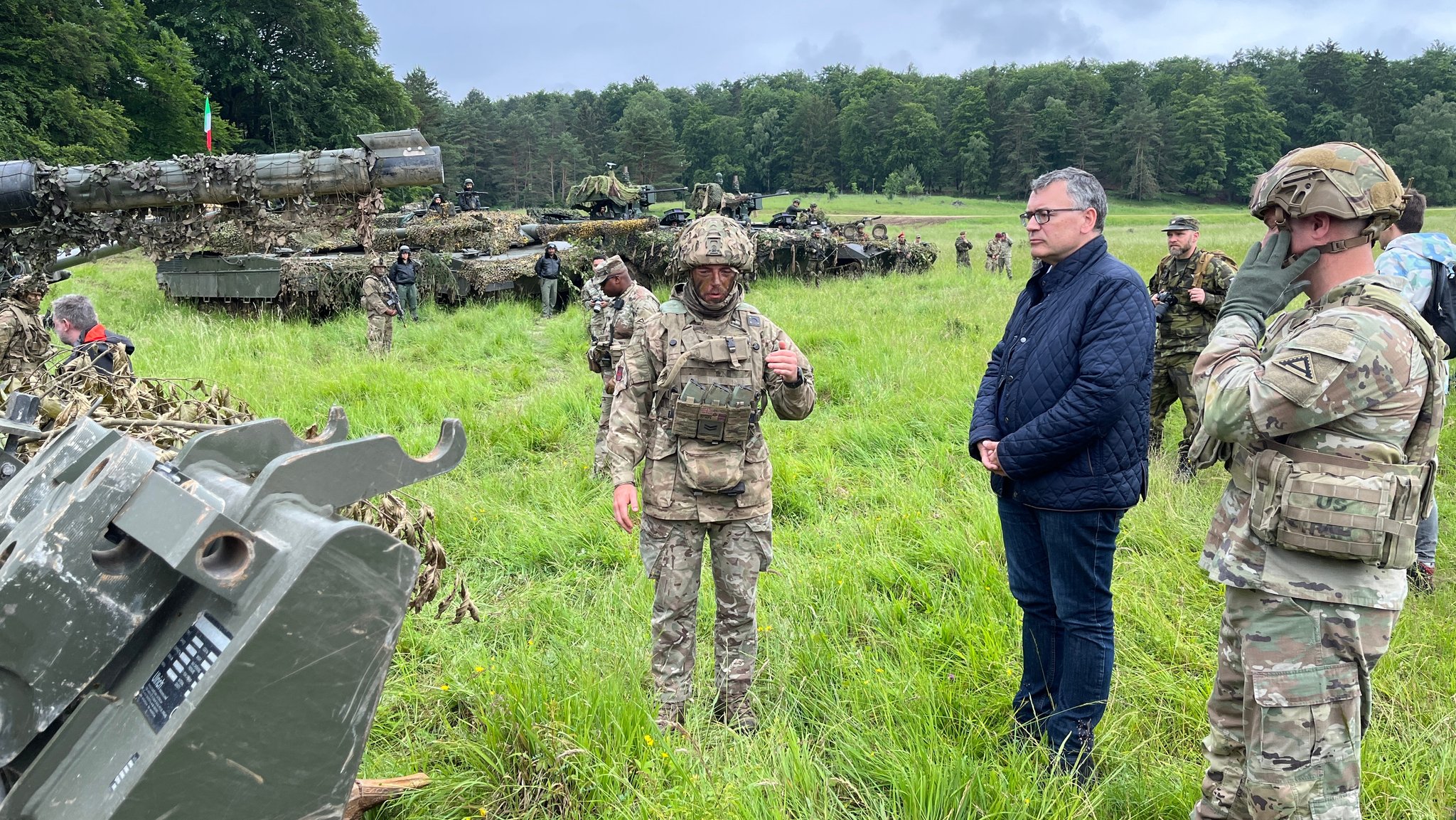 Staatskanzleichef Florian Herrmann (CSU) in dunkler Jacke auf dem Gefechtsfeld des US-Truppenübungsplatzes Hohenfels.