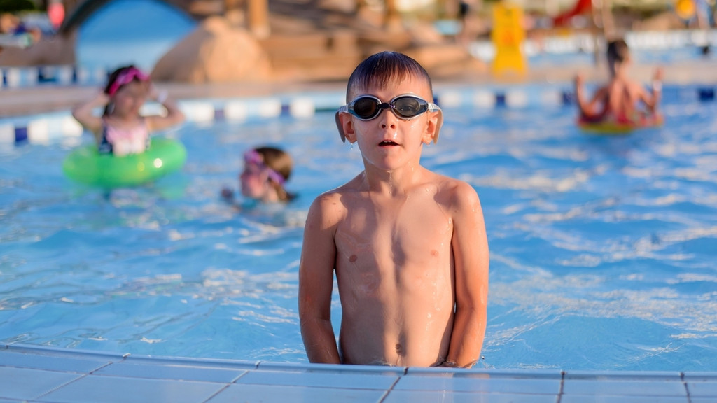 Ein Junge planscht im Freibad. Der Chlor-Geruch im Schwimmbad entsteht erst in Kombination mit Urin. 