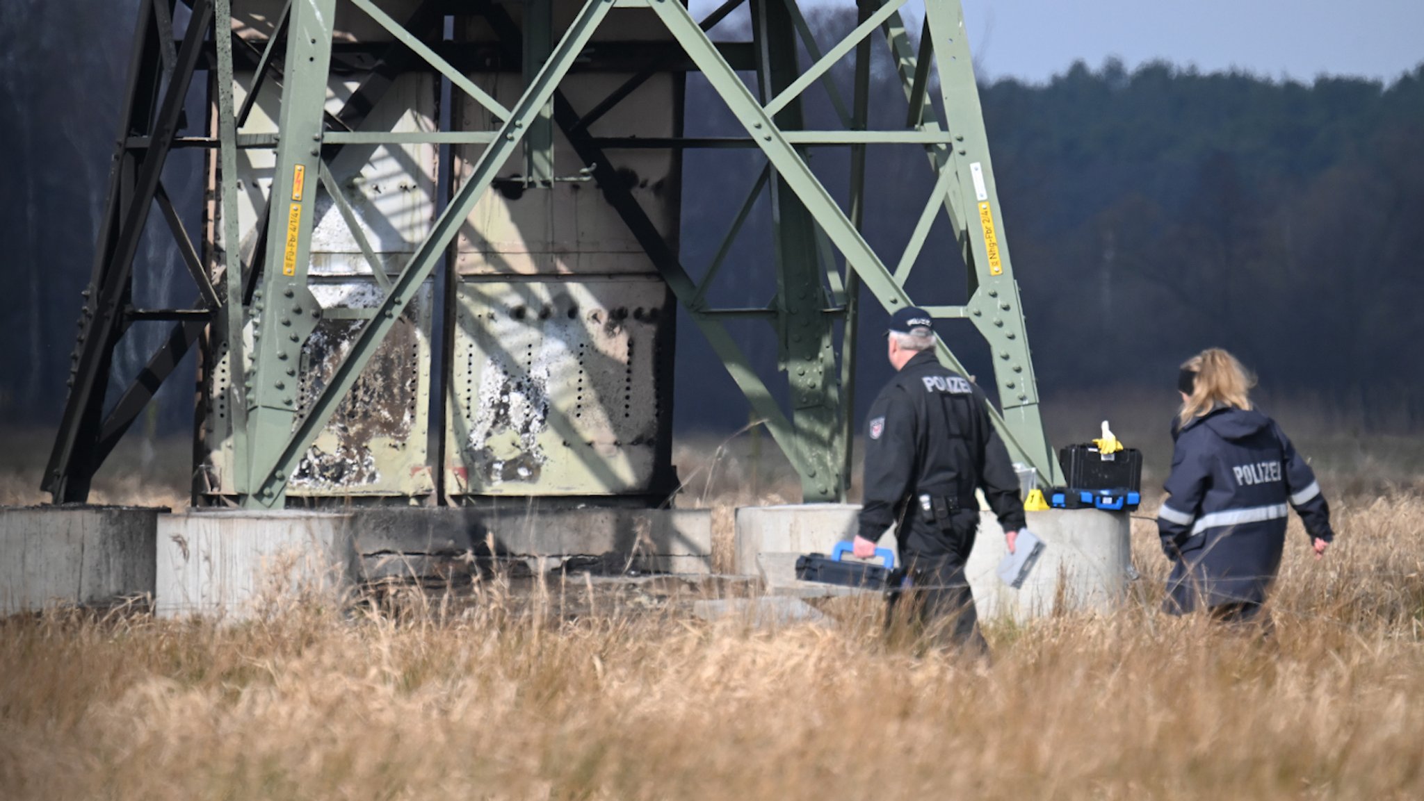 Polizeibeamte inspizieren Strommast