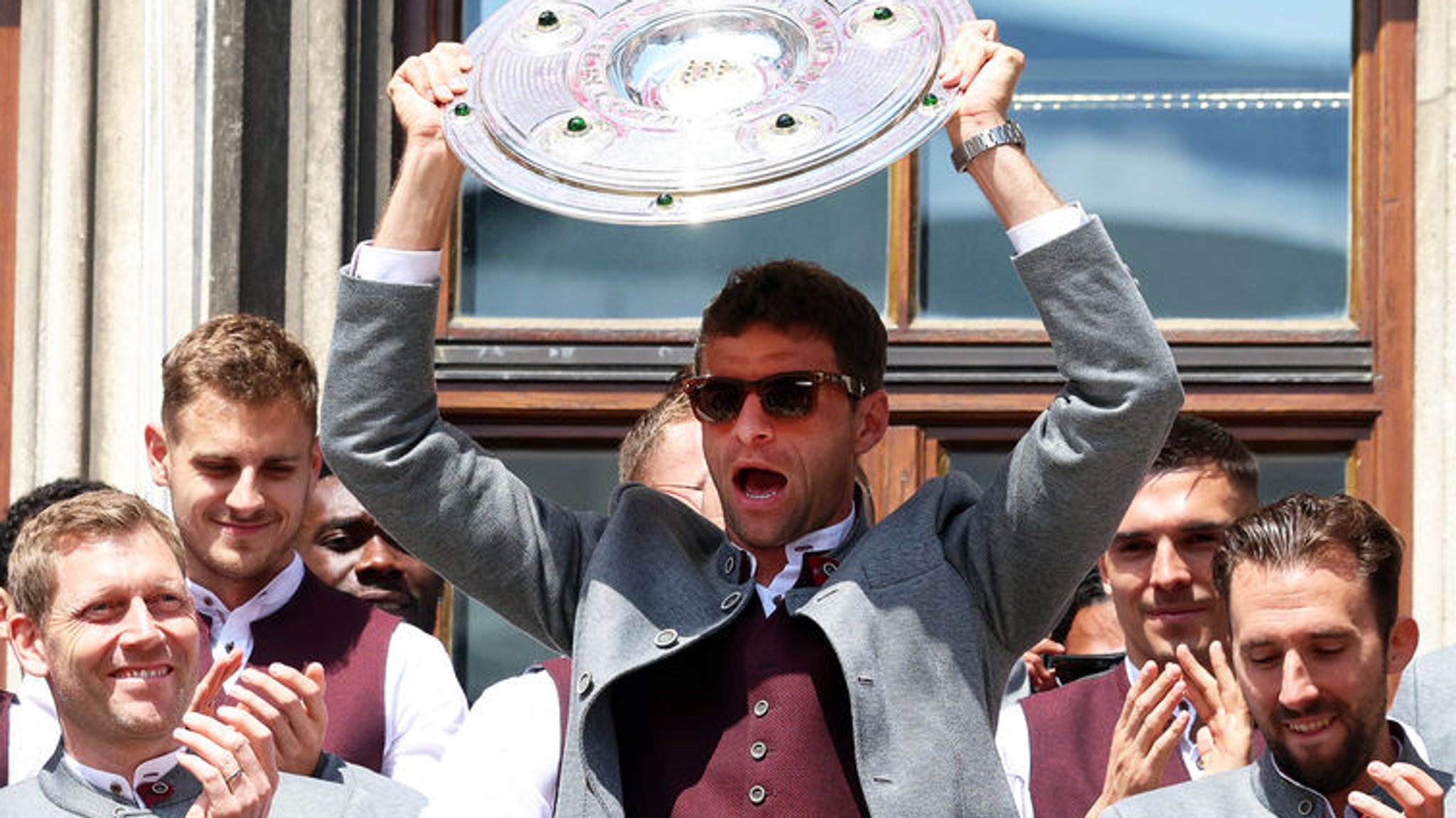 18.05.2025, Bayern, München: Fußball: Bundesliga, Meisterfeier der Fußballerinnen und Fußballer des FC Bayern München, Thomas Müller (Mitte r) jubelt mit der Meisterschale neben den Teamkollegen auf dem Rathaus-Balkon. Foto: Karl-Josef Hildenbrand/dpa +++ dpa-Bildfunk +++