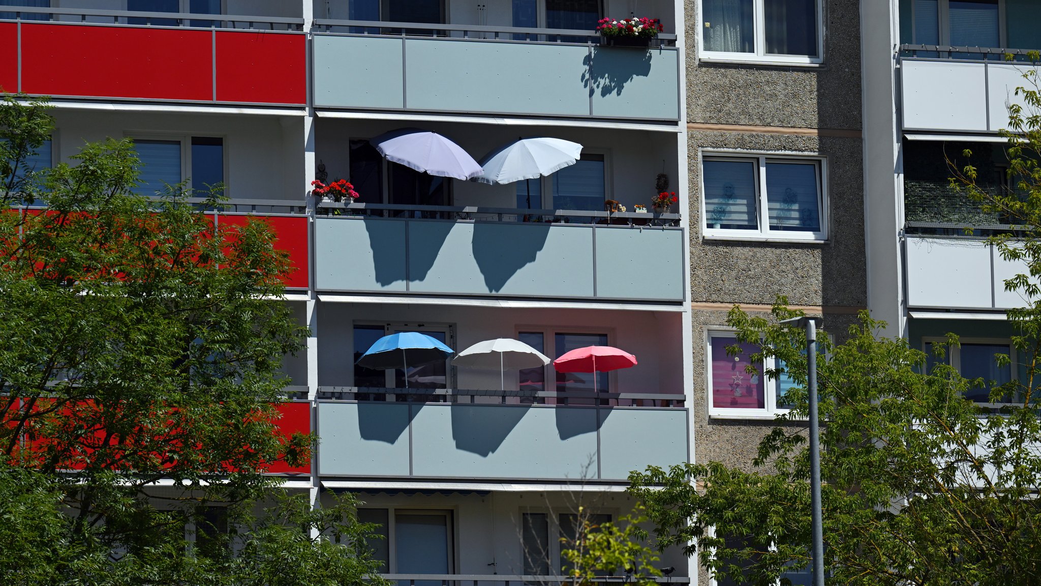 Hausfassade mit Sonnenschirmen (Symbolbild)