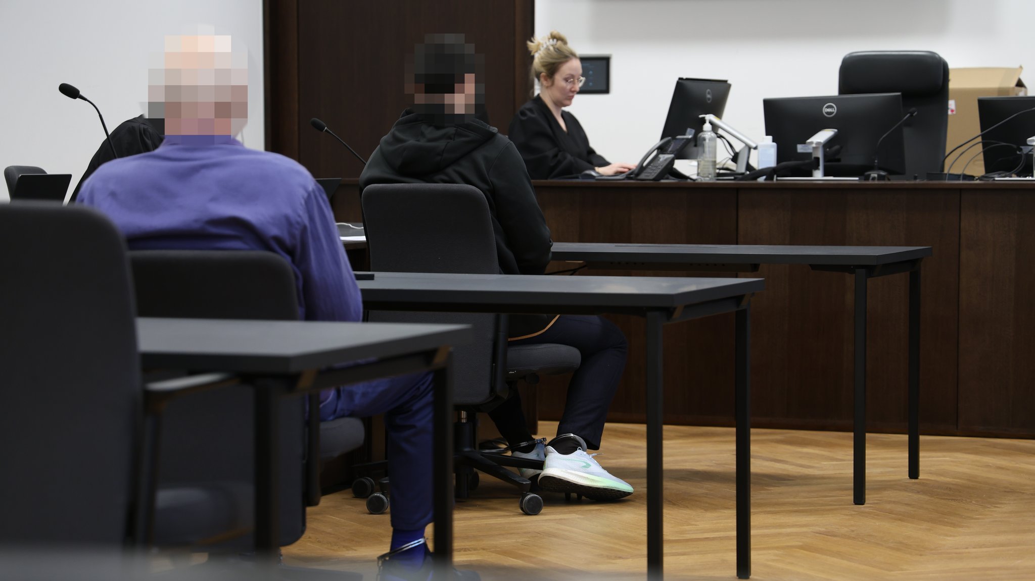 Die Beschuldigten tragen im Gerichtssaal Fußfesseln. 
