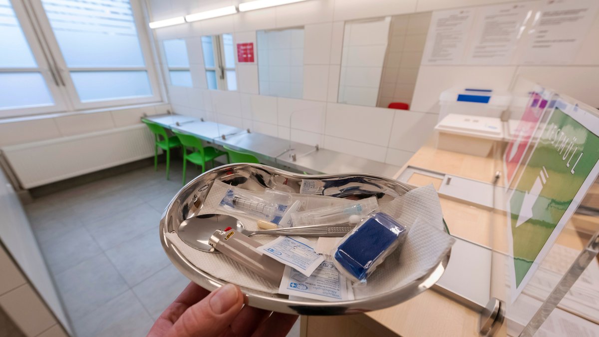 In einem Drogenkonsumraum in Baden-Württemberg zeigt ein Mann eine Schale mit Drogen-Utensilien
