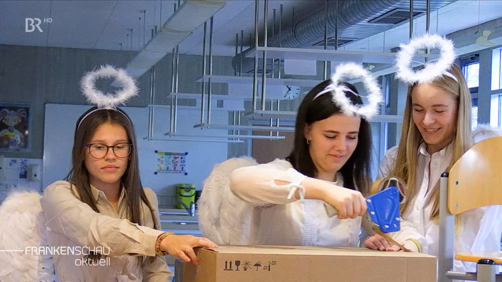 Drei Mädchen in Engelskostüm packen ein Paket. | Bild: BR Drei Mädchen in Engelskostüm packen ein Paket.