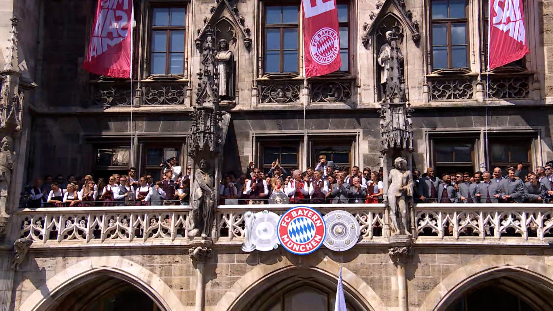 Die Spielerinnen und Spieler des FC Bayern sowie die Verantwortlichen stehen auf dem Münchner Rathausbalkon und lassen sich feiern.