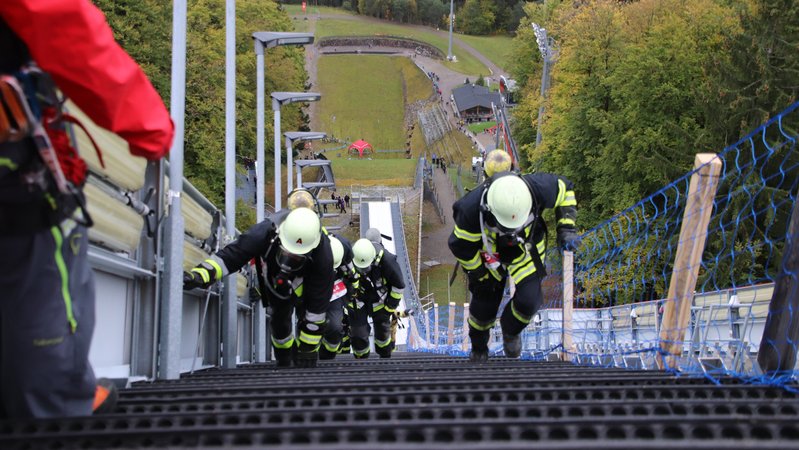 Feuerwehrleute stoßen an ihre Grenzen: In voller Montur müssen sie beim Schanzenlauf die Heini-Klopfer-Schanze in Oberstdorf bezwingen. (Archivbild) | Bild: picture alliance/dpa | Davor Knappmeyer Feuerwehrleute stoßen an ihre Grenzen: In voller Montur müssen sie beim Schanzenlauf die Heini-Klopfer-Schanze in Oberstdorf bezwingen. (Archivbild)